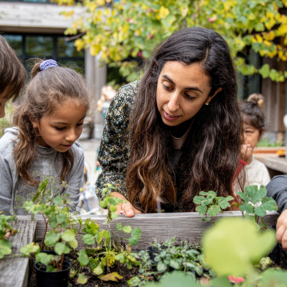 An adult and two children tending plants together in the garden