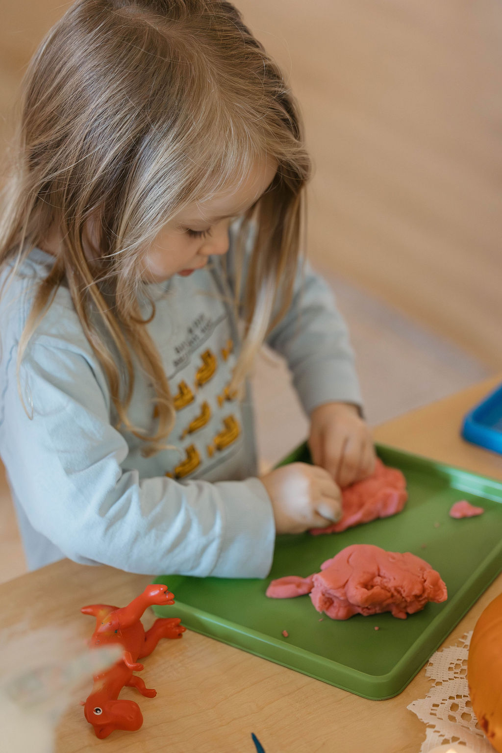 A toddler exploring play dough with her hands