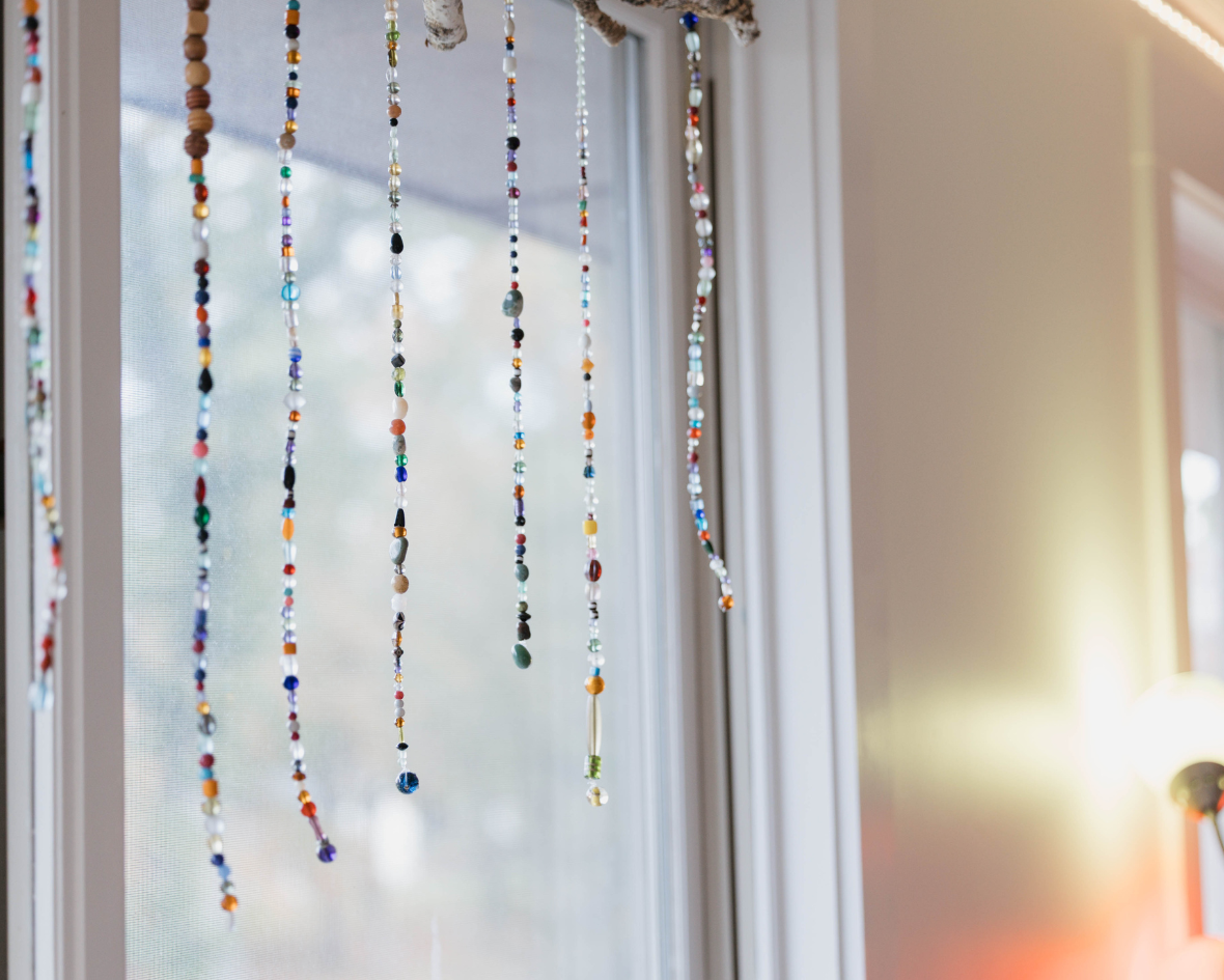 Strands of beads hanging in a sunny classroom window